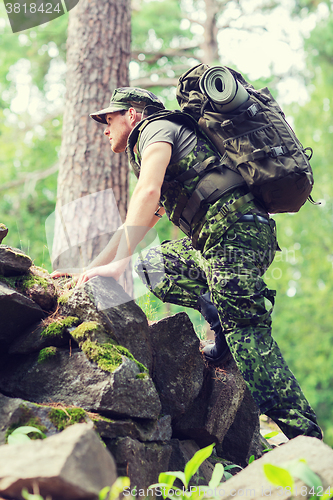 Image of young soldier with backpack in forest