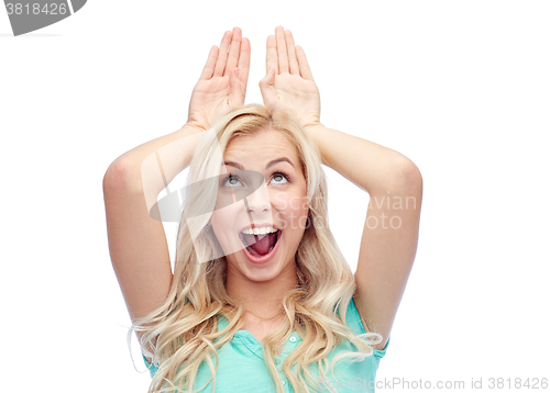 Image of happy smiling young woman making bunny ears