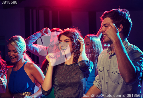 Image of group of happy friends dancing in night club