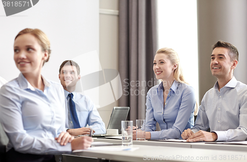 Image of group of smiling businesspeople meeting in office