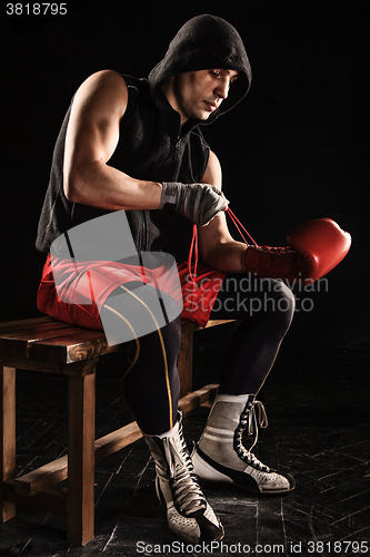 Image of The young  man kickboxing lacing glove