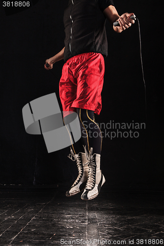 Image of The legs of muscular man with skipping rope