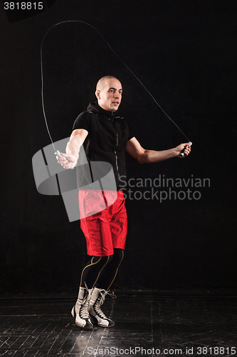 Image of The legs of muscular man with skipping rope