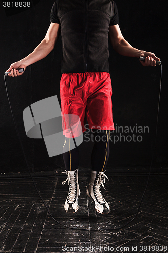 Image of The legs of muscular man with skipping rope