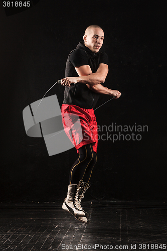 Image of The legs of muscular man with skipping rope