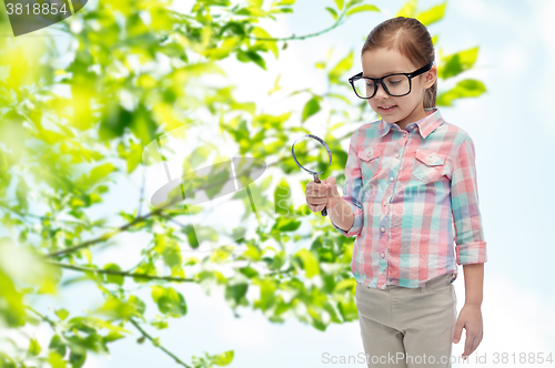 Image of little girl in eyeglasses with magnifying glass