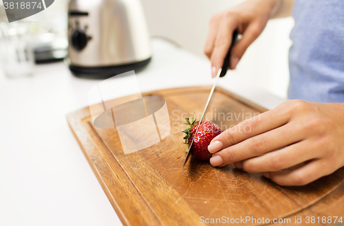 Image of close up of woman chopping strawberry at home