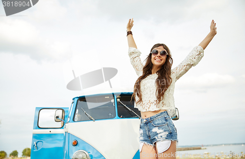 Image of smiling young hippie woman in minivan car