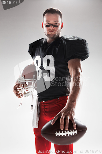 Image of American football player posing with ball on white background