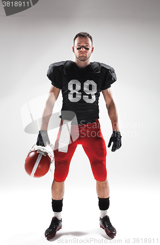 Image of American football player posing with ball on white background