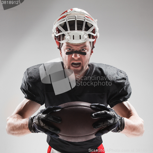 Image of American football player posing with ball on white background