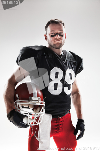 Image of American football player posing with ball on white background