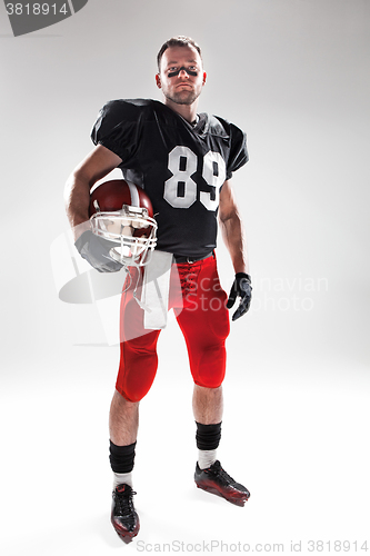 Image of American football player posing with ball on white background