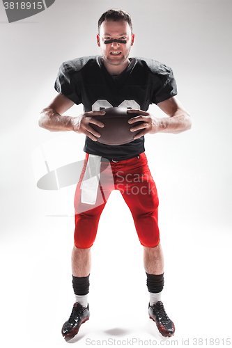 Image of American football player posing with ball on white background