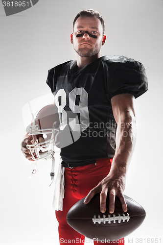 Image of American football player posing with ball on white background