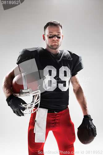 Image of American football player posing with ball on white background