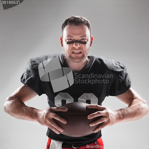 Image of American football player posing with ball on white background