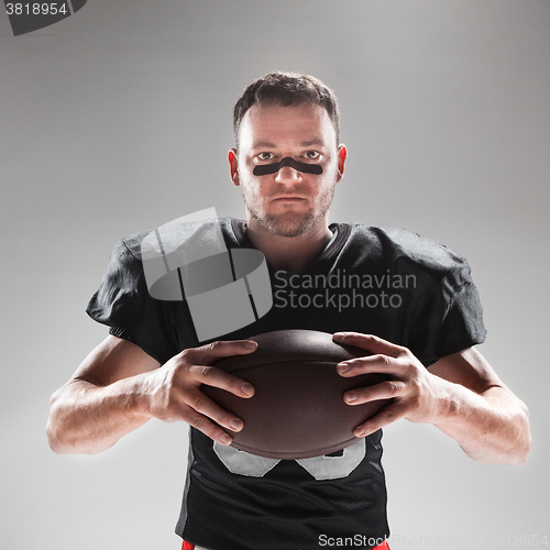 Image of American football player posing with ball on white background