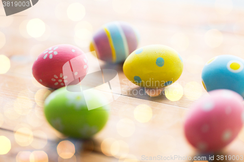 Image of close up of colored easter eggs on wooden surface