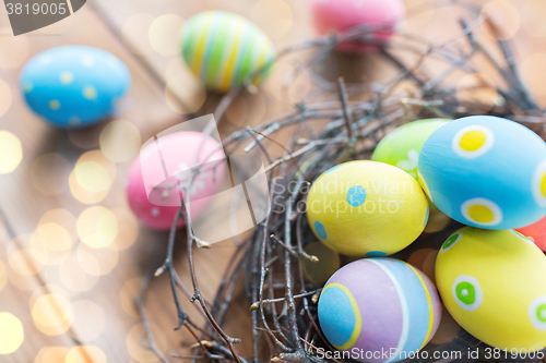 Image of close up of colored easter eggs in nest on wood