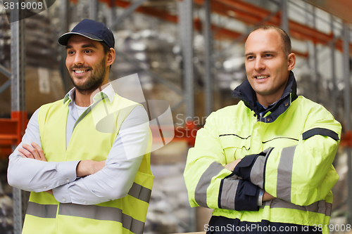 Image of smiling men in reflective uniform at warehouse