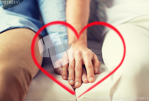 Image of close up of happy male gay couple holding hands