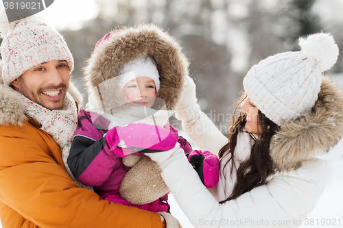 Image of happy family with child in winter clothes outdoors