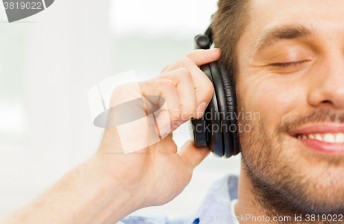 Image of smiling young man in headphones at home