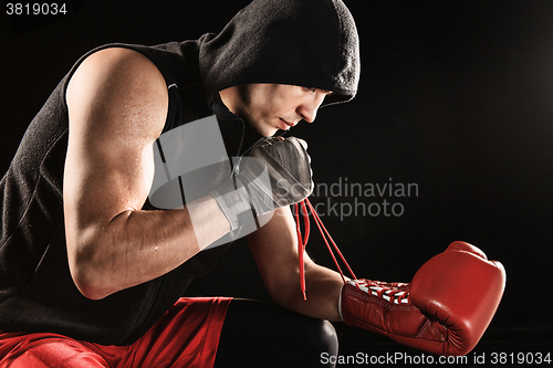 Image of The young  man kickboxing lacing glove