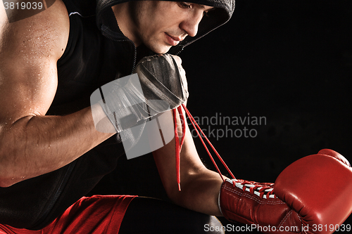 Image of The young  man kickboxing lacing glove