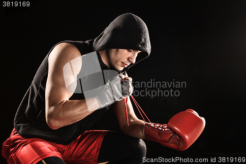 Image of The young  man kickboxing lacing glove