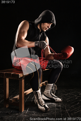 Image of The young  man kickboxing lacing glove