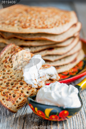 Image of Delicious pancakes with sour cream for breakfast.