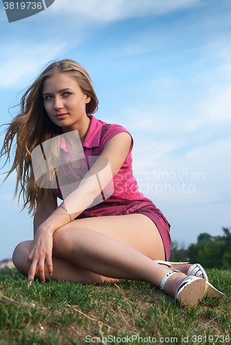 Image of Attractive girl relaxes on grass