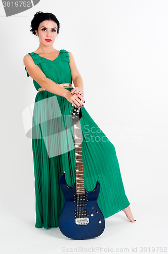 Image of Pretty woman in long green dress with guitar