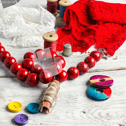 Image of Beads,thread and red cloth