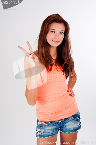 Image of Attractive girl with freckles shows victory sign