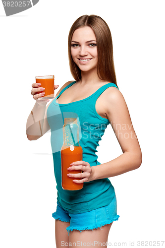 Image of Happy teen girl holding a glass of carrot juice