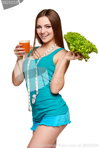 Image of Happy teen girl holding a glass of carrot juice