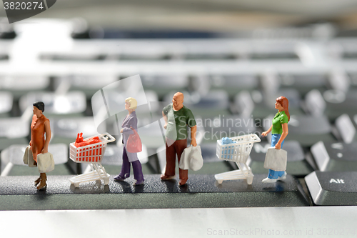 Image of Miniature shoppers  with shopping cart