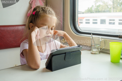 Image of Girl looking at the tablet in the train