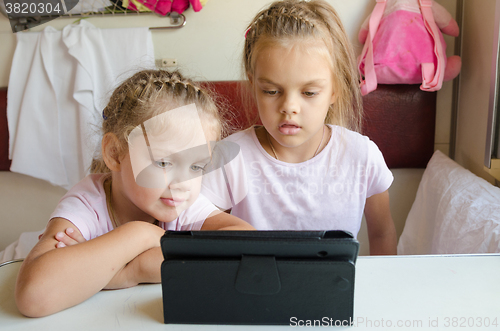 Image of Two girls looking at the tablet in the train