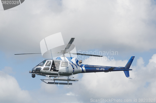 Image of one blue and silver helicopter in the sky