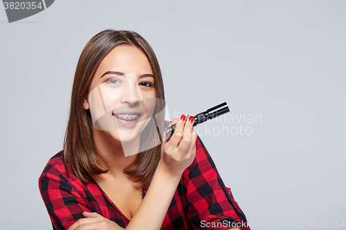 Image of Closeup of smiling female holding pocket flashlight