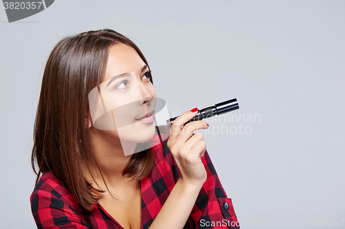 Image of Closeup of smiling female holding pocket flashlight