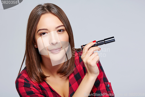 Image of Closeup of smiling female holding pocket flashlight