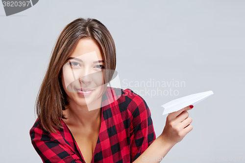 Image of Dreamy female holding white paper plane