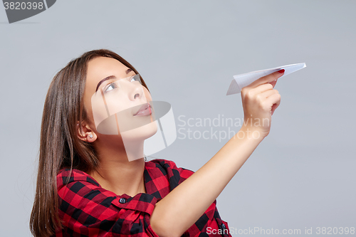 Image of Dreamy female holding white paper plane