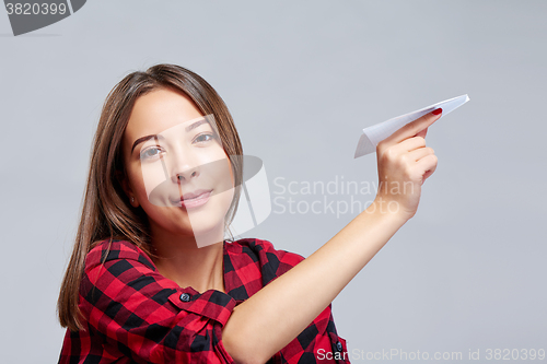 Image of Dreamy female holding white paper plane