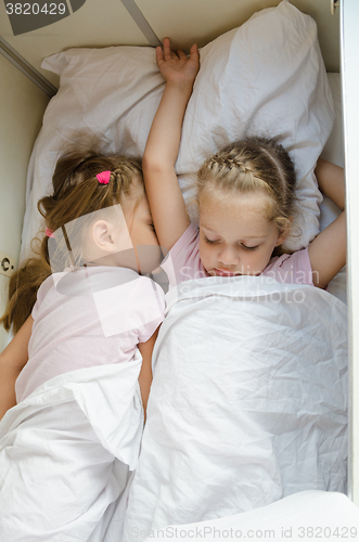 Image of Sisters sleep on the bottom shelf in a train